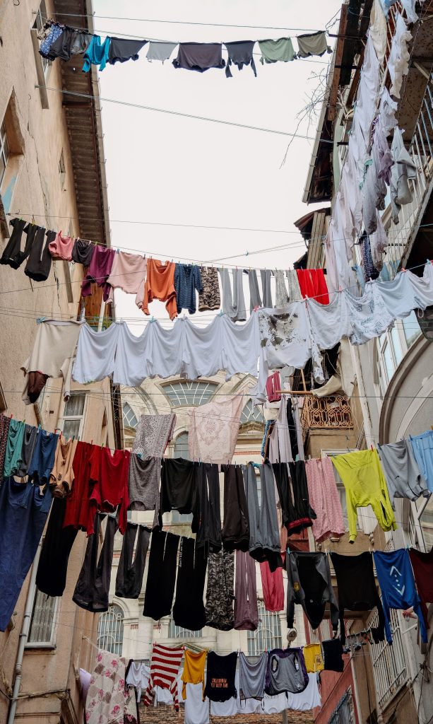 Colorful clothes hanging on lines in an urban setting, creating a vibrant street scene.