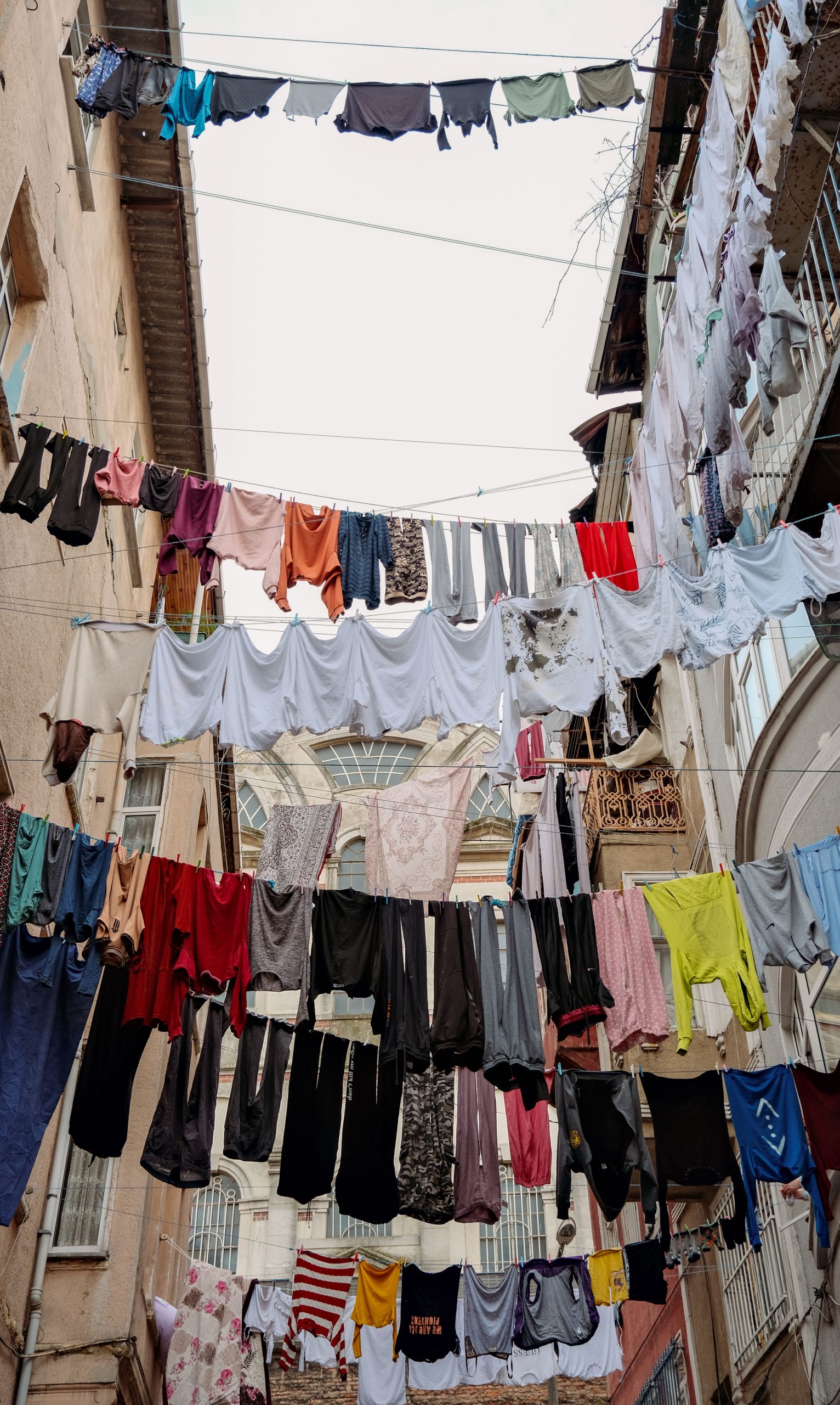Colorful clothes hanging on lines in an urban setting, creating a vibrant street scene.