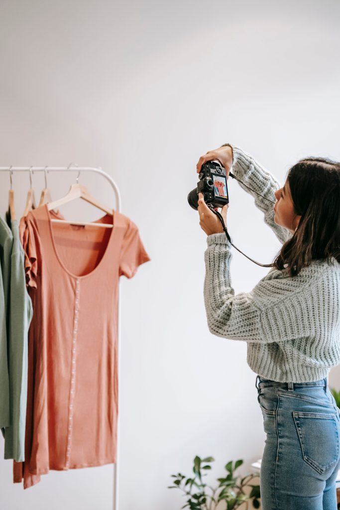 pexels photo 6347934 6347934 Side view of crop Latin American woman taking photo of clothes on digital photo camera against stand